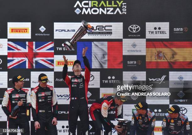 France's Sebastien Ogier celebrates his 8th World title with co-driver France's Julien Ingrassia on the podium, with runner-up Britain's Elfyn Evans...