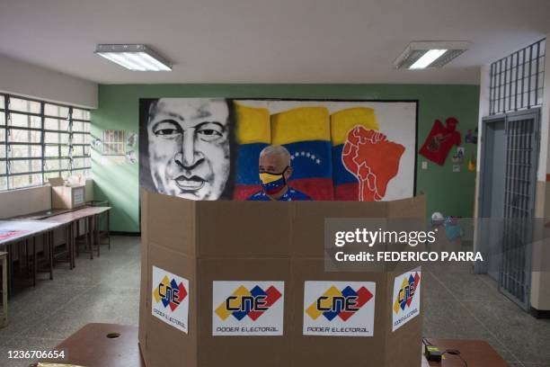 Man wearing a face mask prepares his ballot at a polling station in Caracas during the regional and municipal elections in Venezuela, on November 21,...