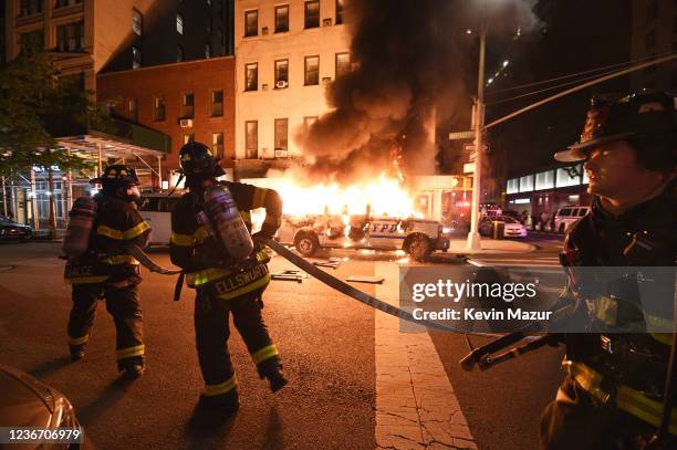 Firefighters work to put out fires on NYPD vehicles caused by protesters near Union Square who are protesting the recent killing of George Floyd on...