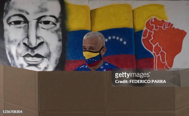 Man wearing a face mask prepares his ballot at a polling station in Caracas during the regional and municipal elections in Venezuela, on November 21,...