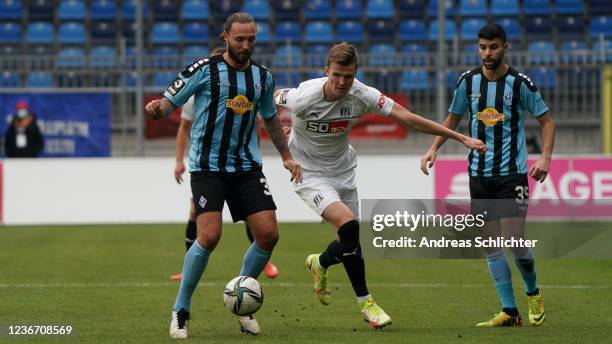 Marco Hoeger and Hamza Saghiri of SV Waldhof Mannheim challenge Lukas Kunze of VfL Osnabrueck during the 3. Liga match between Waldhof Mannheim and...