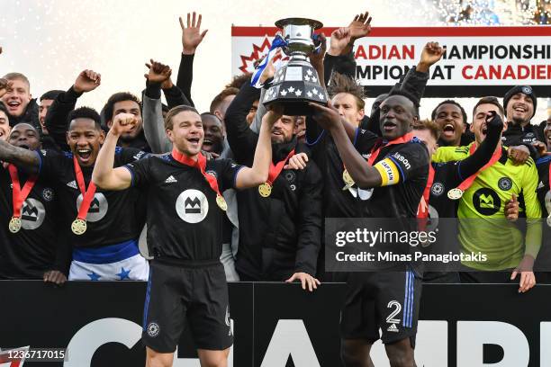 Samuel Piette and Victor Wanyama of CF Montréal hold up the Voyageurs Cup after defeating Toronto FC 1-0 to become the 2021 Canadian Champions at...