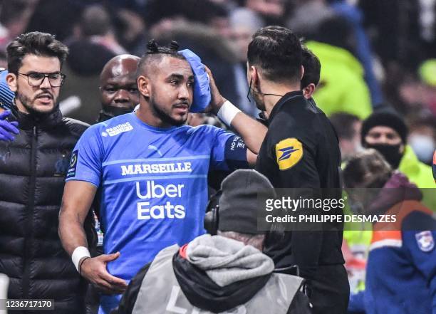 Marseille's French midfielder Dimitri Payet leaves the field after having received a bottle of water from the grandstand during the French L1...