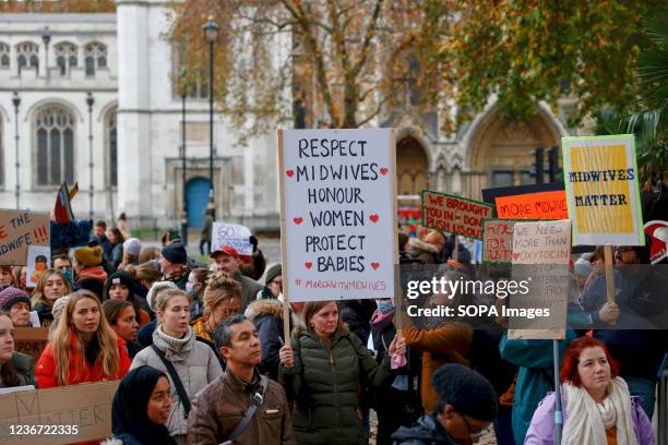 Midwives seen holding placards during the demonstration. Midwives working in the NHS demonstrated across the country over the under-staffing and...