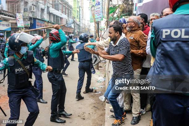 Police personnel charge baton on Bangladesh Nationalist Party supporters as they protest during a rally demanding the government to allow ailing...