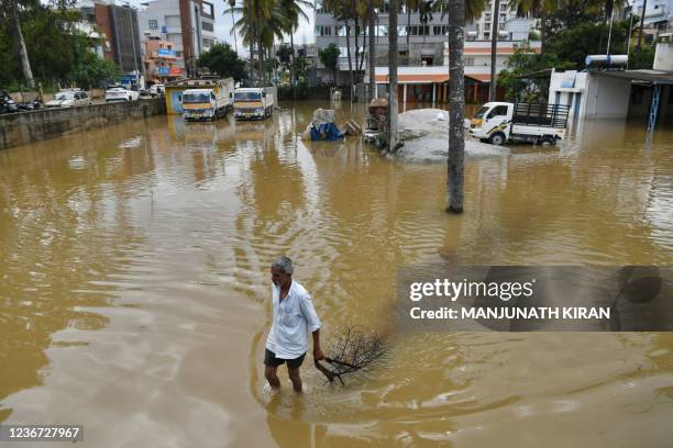 Man wades through a water-logged area following heavy rains in Bangalore on November 22, 2021.