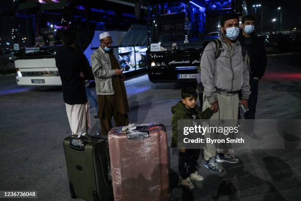 Afghan refugees board buses bound for temporary housing after arriving at Thessaloniki International Airport Makedonia via Kabul on November 22, 2021...