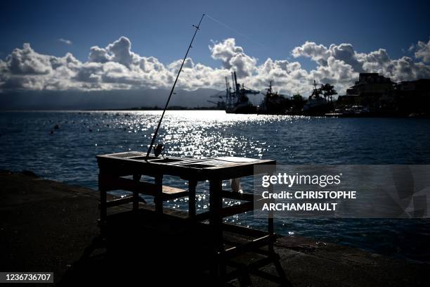 This photograph taken on November 22, 2021 shows an unmanned fishing rod along the Atlantic ocean in central Pointe-a-Pitre on the French Caribbean...