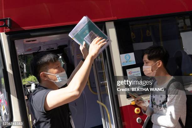 This picture taken November 14, 2021 shows a member of staff instructing passengers to queue up to board a bus operated by a Hong Kong travel agency...