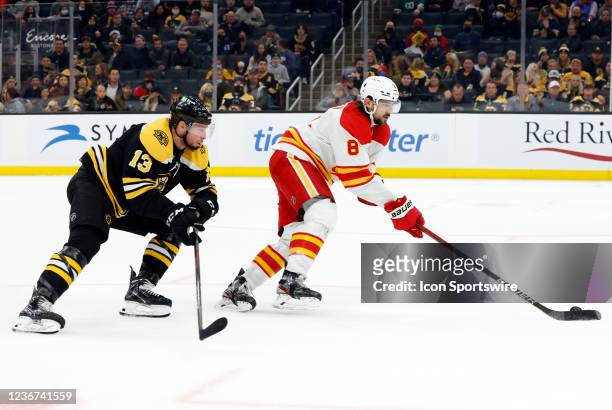 Calgary Flames defenseman Christopher Tanev keeps the puck from Boston Bruins center Charlie Coyle during a game between the Boston Bruins and the...