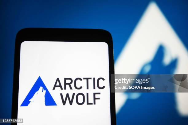 In this photo illustration, the Arctic Wolf Networks logo is seen on a smartphone screen and in the background.