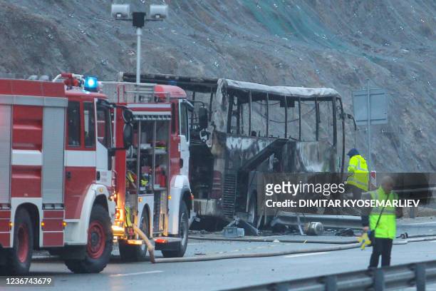 Officials work at the site of a bus accident, in which at least 45 people were killed after the vehicle caught fire, on a highway near the village of...