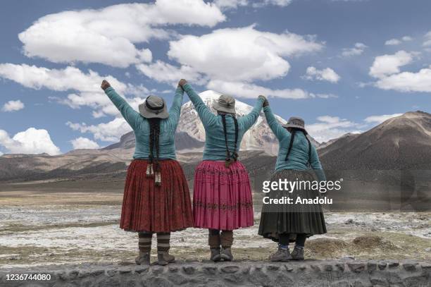 Aymara indigenous women called âCholitas Escaladoras Mayaâ raise their hands towards the mountain after climbing the Nevado Sajama, the tallest...