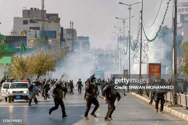 Iraqi riot police keep position as they try to disperse a protest by university students demanding the payment by the government of monthly...