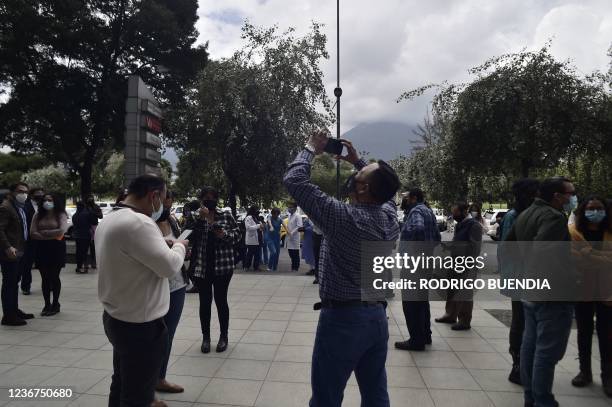 People are seen on the street as they evacuate buildings due to a 4.5 degree quake in Quito, on November 23, 2021.