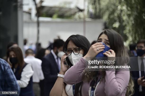 People are seen on the street as they evacuate buildings due to a 4.5 degree quake in Quito, on November 23, 2021.