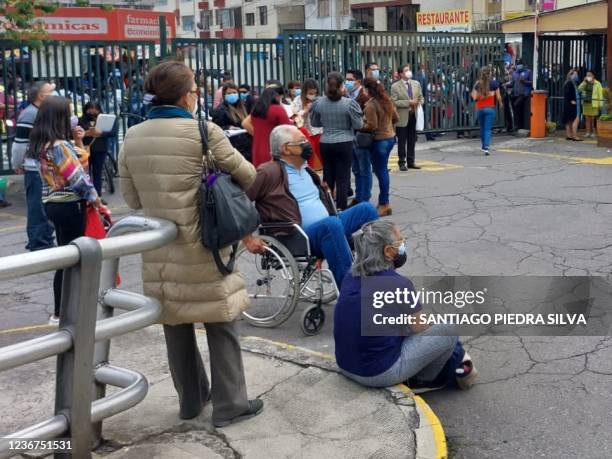 Medical personnel and patients are seen outside a public hospital after evacuating it due to a 4.5 degree quake in Quito, on November 23, 2021.