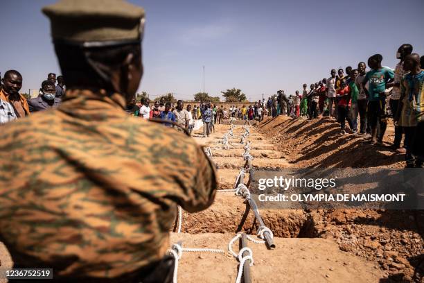 Military official stands by the graves during the burial in the military section at Gounghin Cemetery in Ouagadougou, on November 23, 2021 prepared...