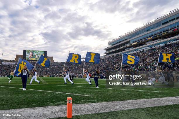 Notre Dame Fighting Irish cheerleaders celebrate with Notre Dame Fighting Irish flags after a touchdown play during a game between the Notre Dame...