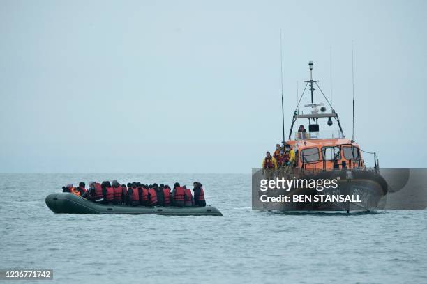 Migrants are helped by RNLI lifeboat before being taken to a beach in Dungeness, on the south-east coast of England, on November 24 after crossing...