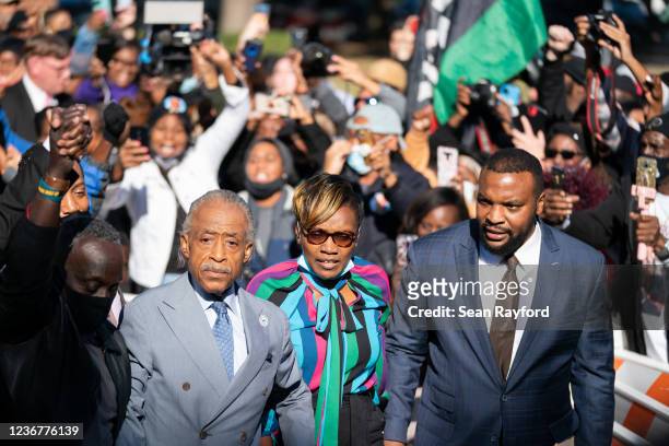 Ahmaud Arbery's mother Wanda Cooper-Jones, attorney Lee Merritt, right, and Rev. Al Sharpton are greeted outside the Glynn County Courthouse...