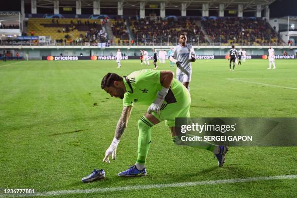 Sheriff's Greek goalkeeper Giorgos Athanasiadis picks up the shoe lost by Real Madrid's Brazilian forward Rodrygo during the UEFA Champions League...