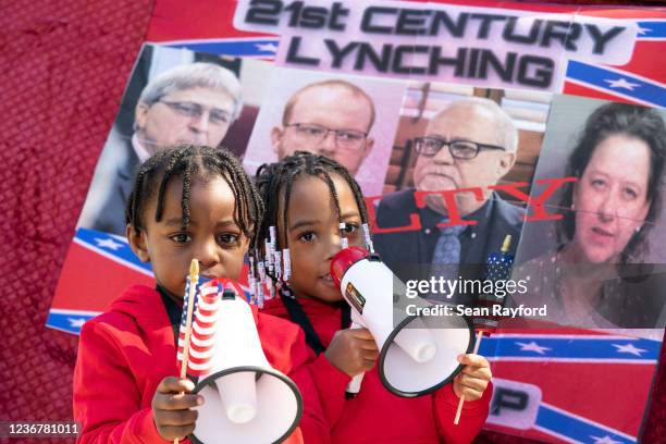 Three year-old Curtis Hayes III and four year-old T'Kyrra Terrell use megaphones outside the Glynn County Courthouse as the jury deliberates in the...