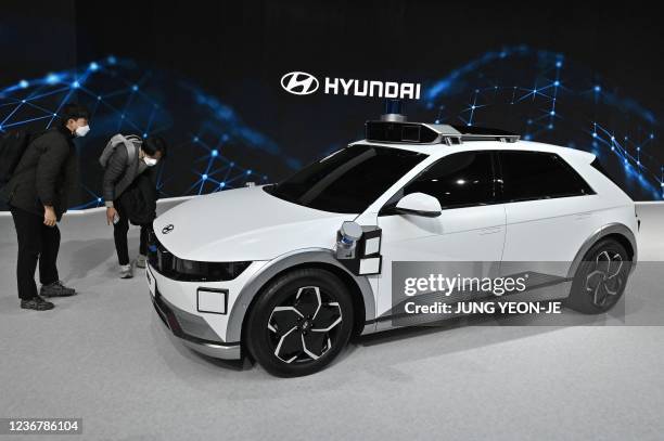 Visitors look at Hyundai Motor's Ioniq 5 Robotaxi electric car during a press preview of the Seoul Mobility Show at KINTEX exhibition hall in Goyang...