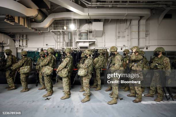 Members of the Japan Ground Self-Defense Force prepare to board a Japan Maritime Self-Defense Force Landing Craft Air Cushion from the JMSDF JS...