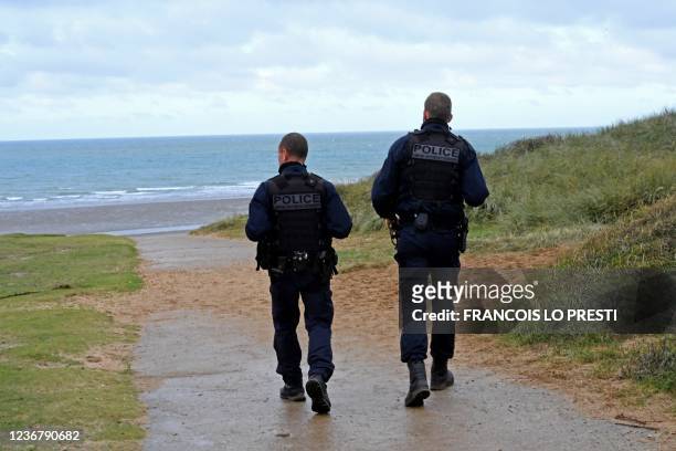 Police officers patrol on the beach of Wimereux on November 25, 2021 following the accident which left 27 migrants dead the day before. - Britain and...