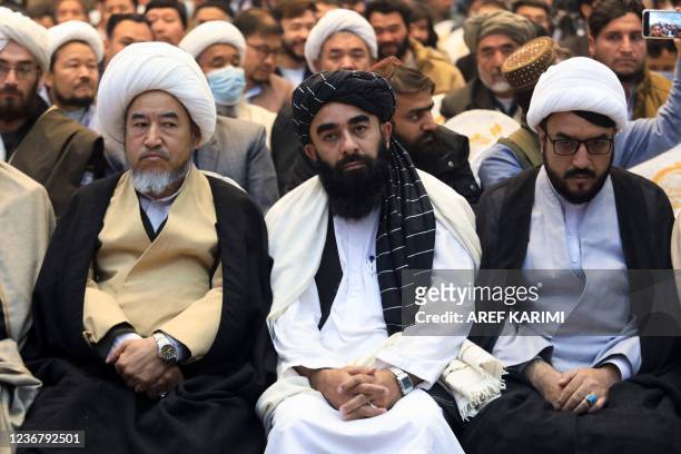 Chief spokesman for the Taliban Zabihullah Mujahid looks on as he attends a gathering where Afghan Hazara elders pledged their support to the...
