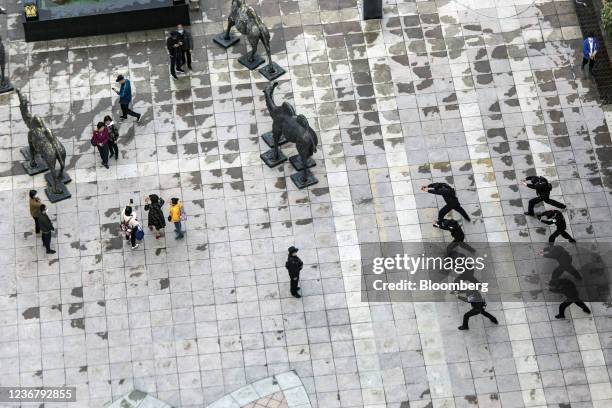 Bloomberg Best of the Year 2021: A squad of police officers performs stretches in a square at the Xinjiang International Grand Bazaar in Urumqi,...