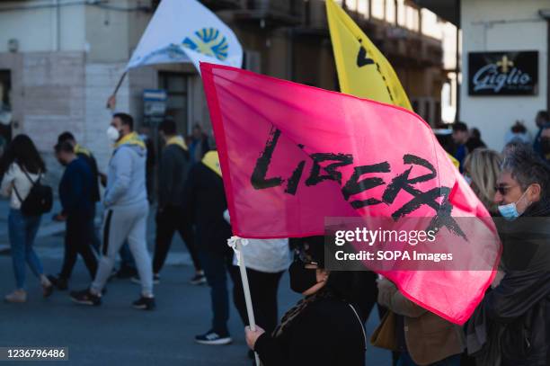 Woman seen holding an anti-mafia association Libera flag during the demonstration. A demonstration against recent intimidations, reportedly done by...