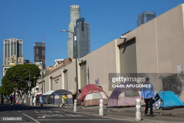 Tents are lined up on the sidewalk in front of the non-profit Midnight Mission's headquarters, while traditional Thanksgiving meals are served to...