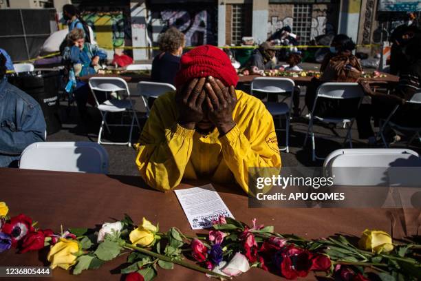 Homeless man holds his head in his hands as he waits for a plate of food during the traditional Thanksgiving meal served by the non-profit Midnight...