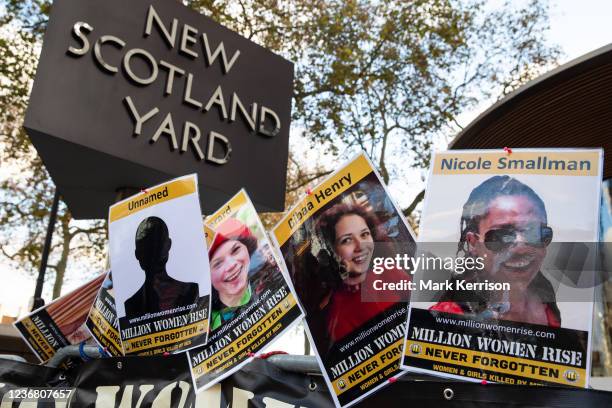 Images of victims of male violence are pictured outside New Scotland Yard during a vigil by dozens of supporters of Million Women Rise to mark the...