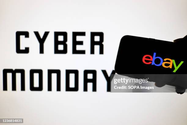 In this photo illustration, an eBay logo seen displayed on a smartphone with a Cyber Monday in the background.