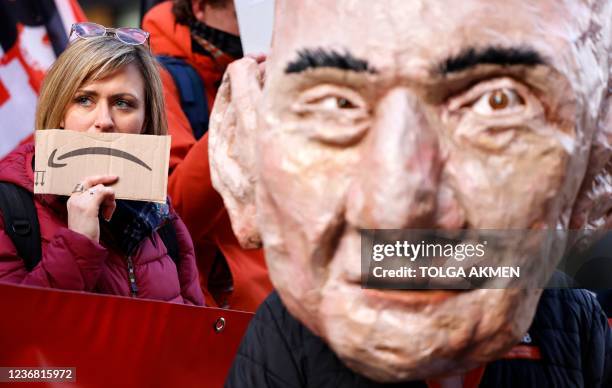 An activist from the Extinction Rebellion climate change group, wearing a mask depicting Jeff Bezos, takes part in a protest outside of Amazon's...