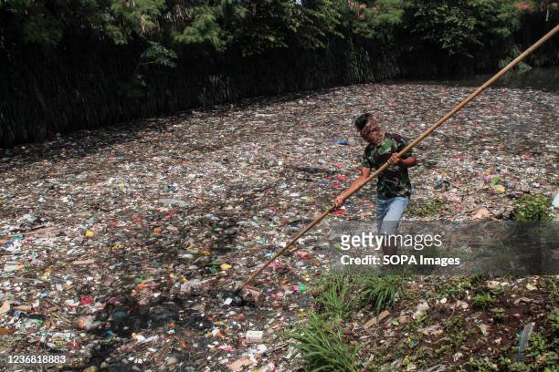 Man nets plastic waste to let water flow in the Bojong Citepus River which empties into the Citarum River in Dayeuhkolot. The National Plastic Action...
