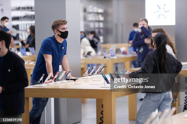 The Apple store employee helps customers during Black Friday at International Plaza on November 26, 2021 in Tampa, United States. More shoppers are...