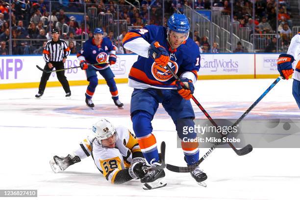 Kris Letang of the Pittsburgh Penguins dives against Andy Andreoff of the New York Islanders during the first period at UBS Arena on November 26,...