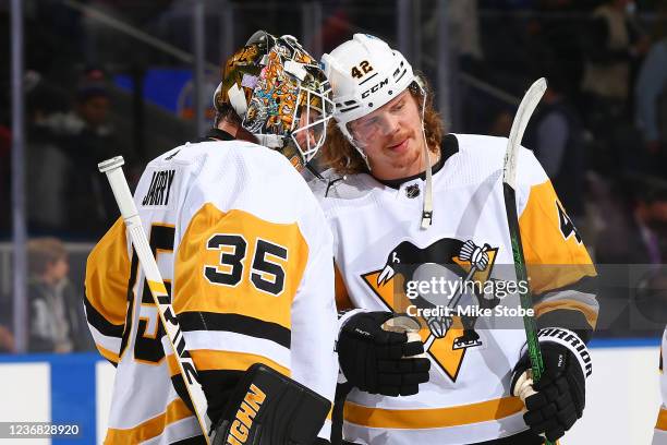 Tristan Jarry and Kasperi Kapanen of the Pittsburgh Penguins celebrate the team's 1-0 win against the New York Islanders at UBS Arena on November 26,...