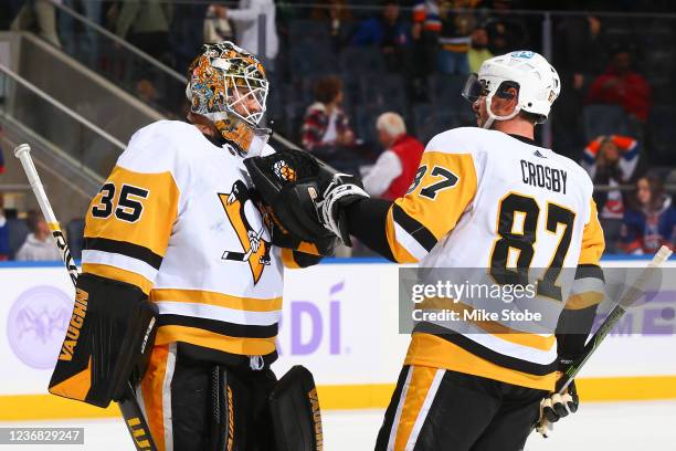 Tristan Jarry and Sidney Crosby of the Pittsburgh Penguins celebrate the team's 1-0 win against the New York Islanders at UBS Arena on November 26,...