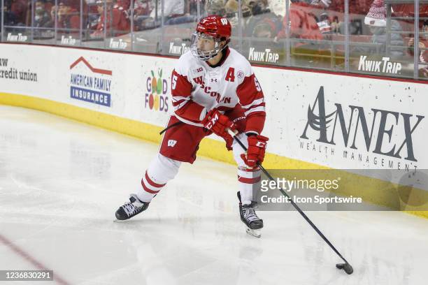 Wisconsin defenseman Tyler Inamoto looks to pass the puck during a college hockey match between the University of Wisconsin Badgers and the Clarkson...