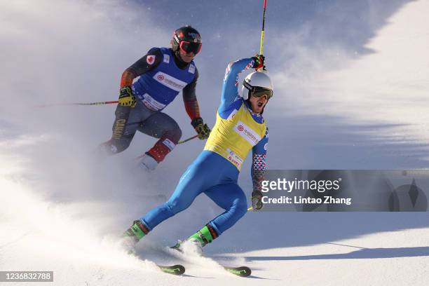 Sergey Ridzik of Russia celebrates after crossing the finish line ahead of Johannes Rohrweck of Austria to win the Men's Ski Cross finals of Audi FIS...