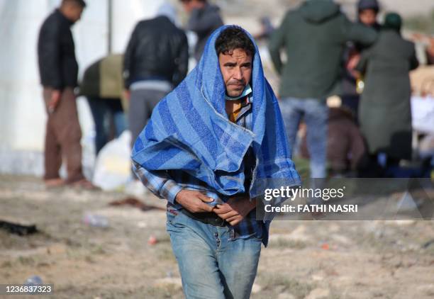 Migrant rescued alongside others by Tunisia's national guard during an attempted crossing of the Mediterranean by boat, walks at a makeshift...