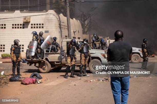 Protestors face security forces firing tear gas during a demonstration in Ouagadougou on November 27, 2021. - Anti-riot police fired tear gas to...