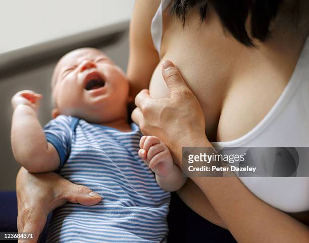 mother suffering from mastitis - ethical treatment foto e immagini stock