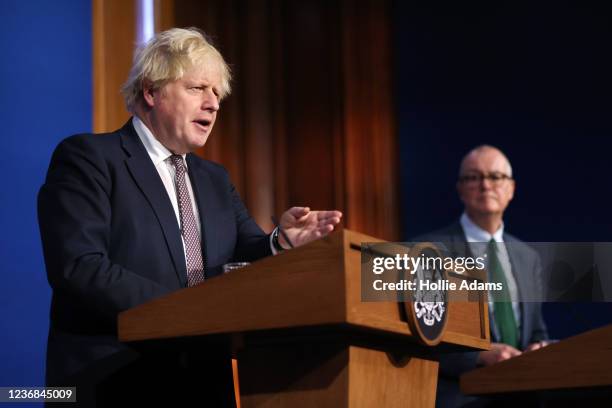 Prime Minister Boris Johnson stands alongside British Chief Scientific Adviser Patrick Vallance during a press conference after cases of the new...