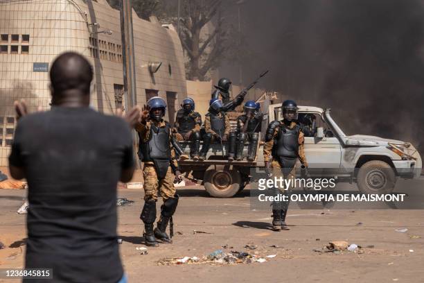 Protestor faces security forces during a demonstration in Ouagadougou on November 27, 2021. Anti-riot police fired tear gas to prevent the...